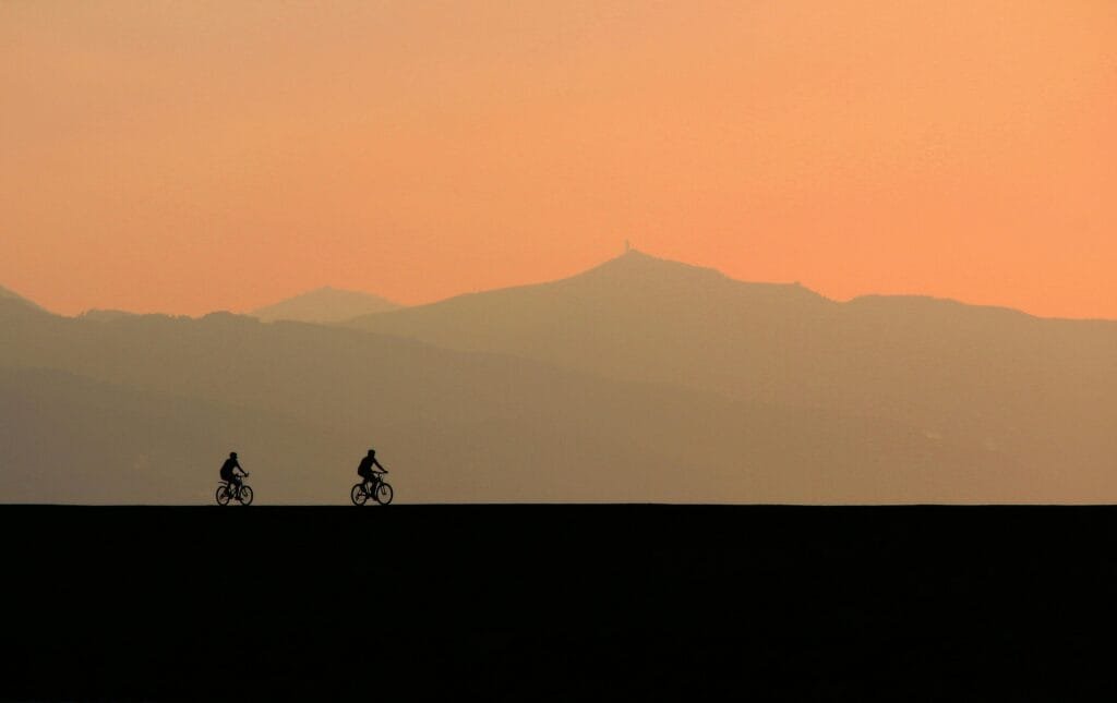 Sunset scenery with two spontaneous people riding their bikes.