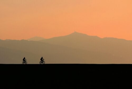 Sunset scenery with two spontaneous people riding their bikes.